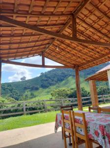 布埃諾布蘭的住宿－Chalés Cachoeira Cafundó，享有美景的木屋顶下桌椅
