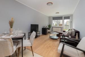 a living room with a table and chairs and a living room at Długie Ogrody Spacious Apartment in the Gdańsk City Center by Renters in Gdańsk