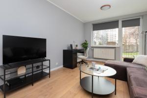a living room with a couch and a tv at Długie Ogrody Spacious Apartment in the Gdańsk City Center by Renters in Gdańsk