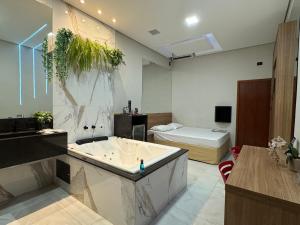 a large bathroom with a tub and a bed at Motel Stilo - Adults Only in Contagem