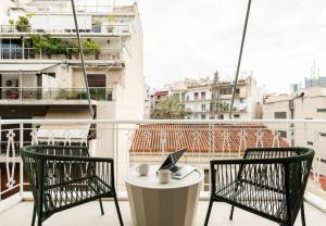 - un balcon avec deux chaises et un ordinateur portable sur une table dans l'établissement Glamorous 4th FL Apt in Kolonaki 6 min to Syntagma, à Athènes