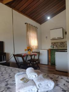 uma sala de estar com uma mesa e uma cozinha em Chalés Cachoeira Cafundó em Bueno Brandão