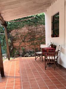 eine Terrasse mit einem Tisch, Stühlen und einer Ziegelwand in der Unterkunft Casa Incone in Formosa