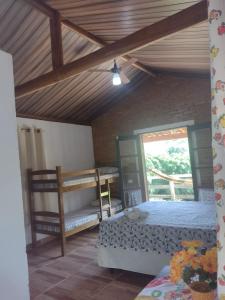 - une chambre avec deux lits superposés et un plafond dans l'établissement Chalés Cachoeira Cafundó, à Bueno Brandão