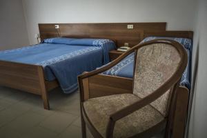 1 dormitorio con 1 cama y 1 silla en Albergo Sporting, en Endine Gaiano