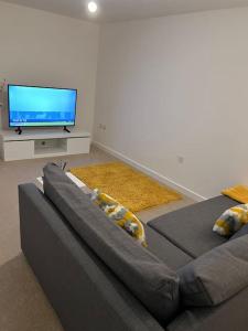 a living room with a couch and a flat screen tv at Brand New 3 Bedrooms Detached House in Westhoughton