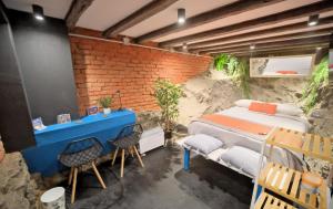 um quarto com uma cama e duas cadeiras em Maki Hostels & Suites Valparaiso em Valparaíso