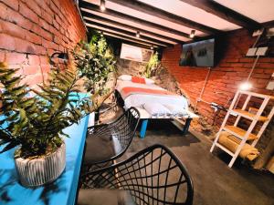1 dormitorio con 1 cama en una pared de ladrillo en Maki Hostels & Suites Valparaiso, en Valparaíso