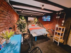 Maki Hostels & Suites Valparaiso في فالبارايسو: غرفة نوم بسرير وجدار من الطوب