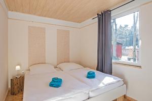 a bedroom with a bed with blue slippers on it at Krebssee in Ueckeritz