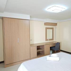 a bedroom with a bed and a vanity and a mirror at Omni Suites Serviced Apartment 1Bedroom in Bangkok