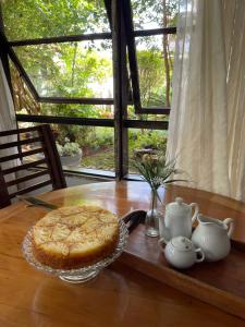 a pie sitting on a wooden table with a table at Pousada das Artes in Tiradentes
