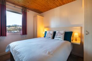 a bedroom with a large white bed with two lamps at Hunters Quay -3 Bedroom Lodge in Kirn