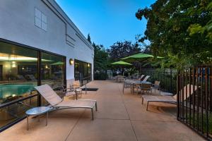 un patio con sillas, mesas y una piscina en SpringHill Suites Boise West/Eagle, en Boise