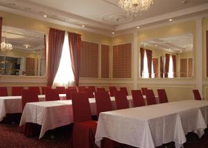 a conference room with white tables and red chairs at Optima Collection Kamianets-Podilskyi in Kamianets-Podilskyi