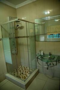 ein Bad mit einer Glasdusche und einem Waschbecken in der Unterkunft Gorge View. in Mbabane