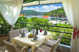 a table on a balcony with a view of a harbor at Villa Barbara in Skradin