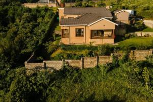 ein Haus auf einem Hügel mit einem Zaun in der Unterkunft Gorge View. in Mbabane