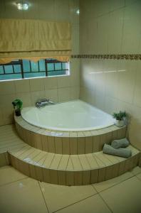 eine große Badewanne im Bad mit Fenster in der Unterkunft Gorge View. in Mbabane