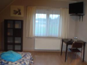 a bedroom with a bed and a desk and a window at Auro'ra in Zedelgem