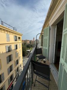 een balkon met 2 stoelen en een tafel op een gebouw bij Aston - Appartement Centre Ville Massena in Nice