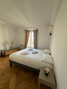 een slaapkamer met een groot bed en een raam bij Aston - Appartement Centre Ville Massena in Nice