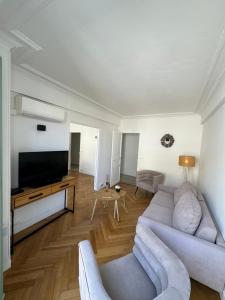 uma sala de estar com um sofá e uma televisão de ecrã plano em Aston - Appartement Centre Ville Massena em Nice