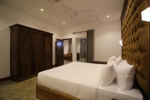 a bedroom with a large bed with white sheets and pillows at Hotel Refresh Blue in Hikkaduwa