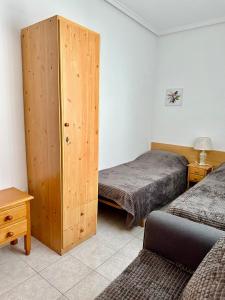トレビエハにあるApartamentos Avenida Diego Ramirezのベッドルーム1室(ベッド2台、木製キャビネット付)