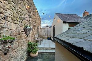 a small patio with a stone wall and some plants at Cosy Matlock Cottage with Fireplace, Stunning Views & Pet Friendly in Two Dales