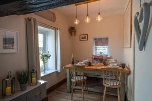 a kitchen with a table and chairs in a room at Cosy Matlock Cottage with Fireplace, Stunning Views & Pet Friendly in Two Dales