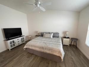 a bedroom with a bed and a flat screen tv at Tinsley - Patio Villa In The Village Of Hawkins in The Villages
