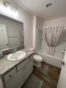a bathroom with a sink and a toilet and a tub at Tinsley - Patio Villa In The Village Of Hawkins in The Villages