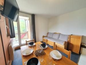 a living room with a table and a couch at Meije 15 - A2 - Appart vue degagee- 6 pers in Les Deux Alpes