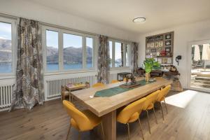 a dining room with a large wooden table and yellow chairs at Garden Hotel Primavera in Brissago