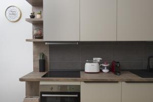 cocina con armarios blancos y encimera en Nuovo Appartamento in Pieno Centro con WiFi E Clima, en Civitanova Marche