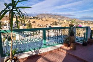 a balcony with a green fence and a palm tree at Dar Sunrise Fes in Fès