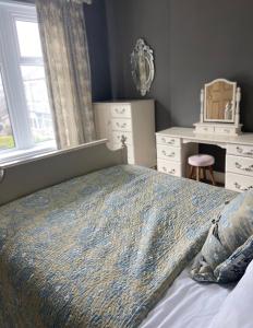 a bedroom with a bed and a desk and a window at Sherwood House in Matlock