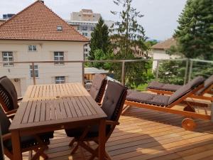 une terrasse en bois avec une table et des chaises sur un balcon dans l'établissement 2 Ljubljana Modern Villa Apartment, à Ljubljana