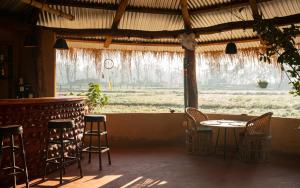 eine Terrasse mit einem Tisch und Stühlen sowie einer Bar in der Unterkunft Sunsetview Bardia in Bardiyā