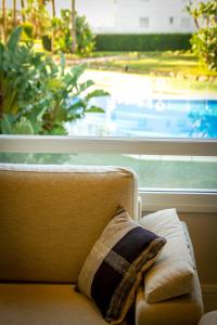 a pillow sitting on a couch in front of a window at MARBELLA BANUS SUITES - Banus Playa Rocio Direct Sea Access in Marbella