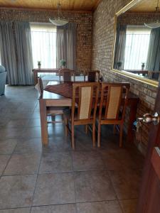 a dining room with a wooden table and chairs at Dream lodging apartment in Vanderbijlpark