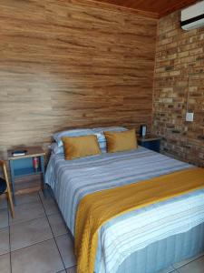 a bedroom with a bed and a brick wall at Dream lodging apartment in Vanderbijlpark