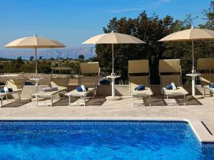 a swimming pool with chairs and umbrellas next to at Holiday Home Petra in Ledenice