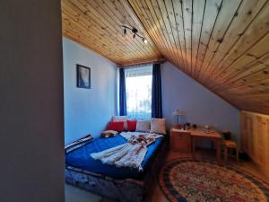 a bedroom with a blue bed with a wooden ceiling at Júlia Apartman in Balatonalmádi