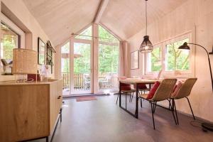 a dining room with a table and chairs and windows at Baumschiffhotel am Waldbad in Bad Rodach