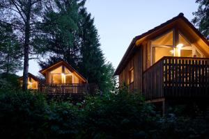 a cabin in the woods with lights on at Baumschiffhotel am Waldbad in Bad Rodach