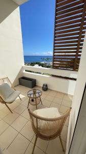 uma varanda com cadeiras e vista para o oceano em Bel appartement vue mer - Mafat'appart em La Possession