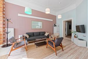 a living room with a couch and a tv at primeflats - Apartments Schillerpark Berlin-Wedding in Berlin