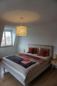 a bedroom with a large bed with a chandelier at Stadt nah, Modern, bequem, in Thun
